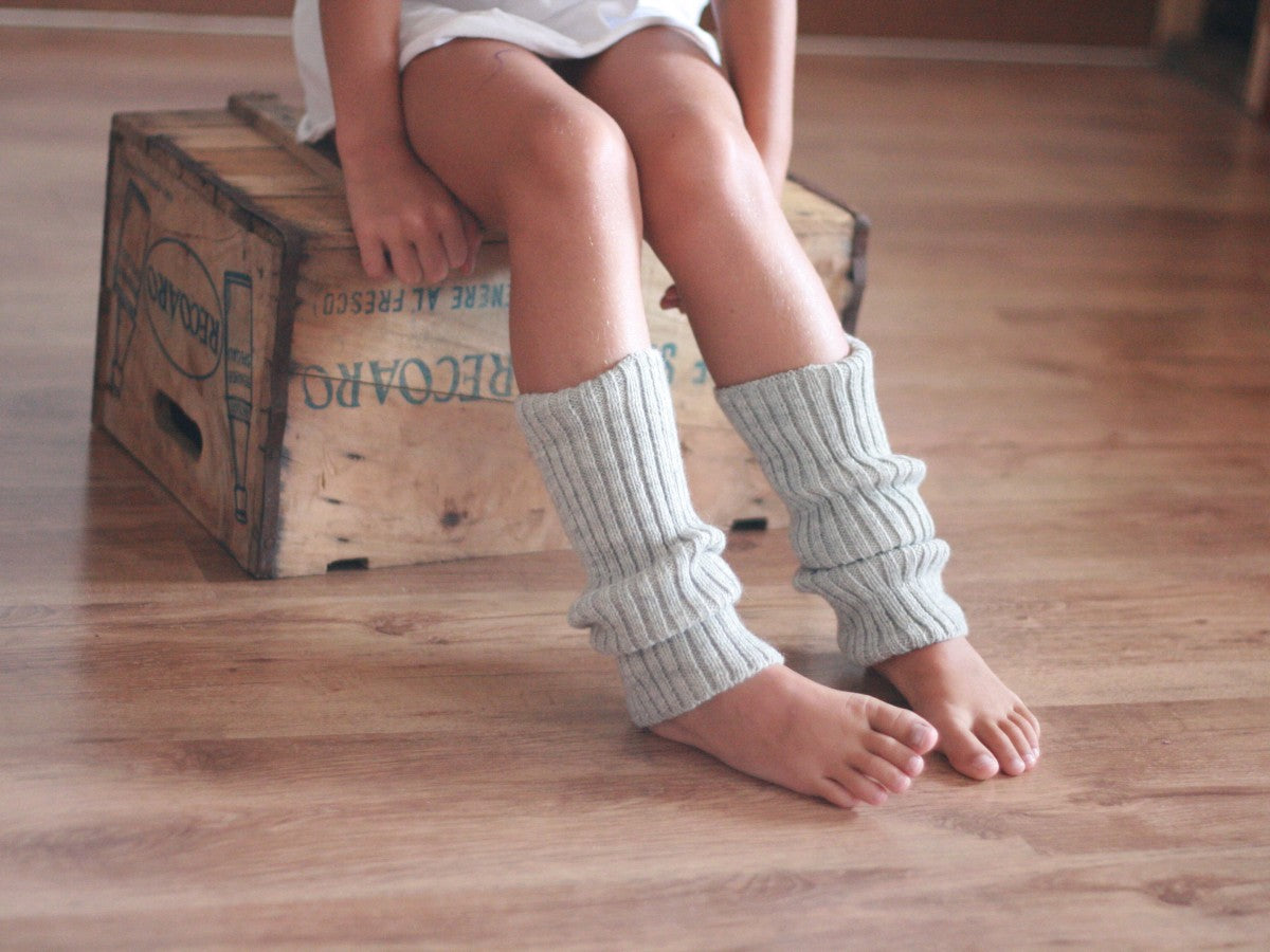 le gambe con i scaldamuscoli grigi