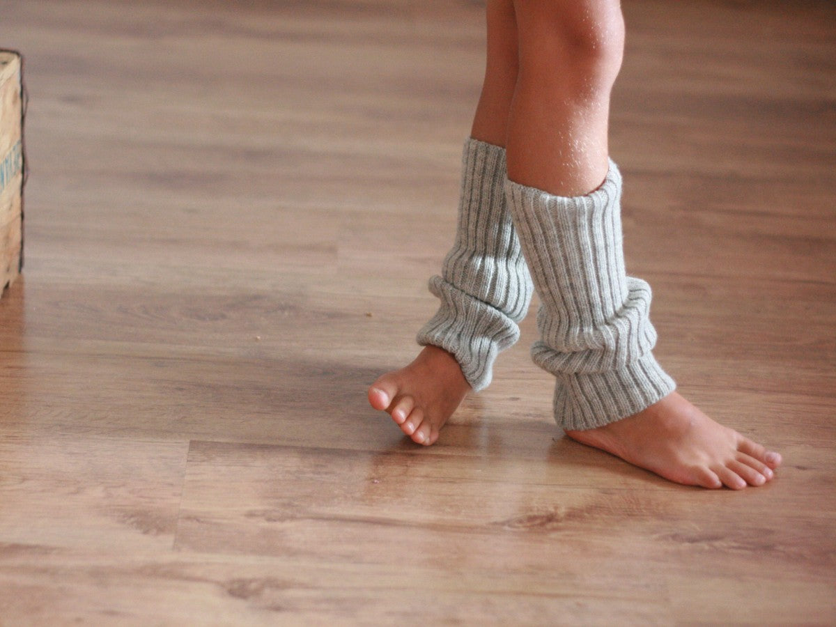 le gambe incrociate con i scaldamuscoli grigi